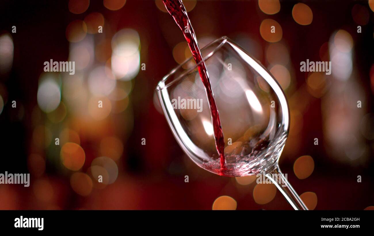 Freeze motion of pouring red wine from bottle into goblet. Low depth of