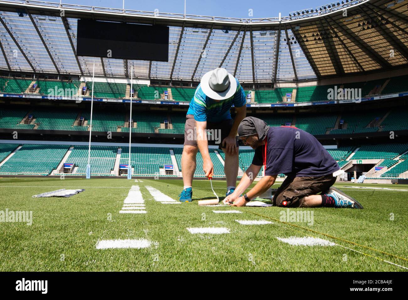 A team of artists work on portraits of rugby players Joe Marler, Maro Itoje and Faf de Klerk on the pitch at Twickenham Stadium in London to celebrate the restart of Gallagher Premiership Rugby on Friday, August 14th when Harlequins take on Sale Sharks at 7:45pm. Stock Photo
