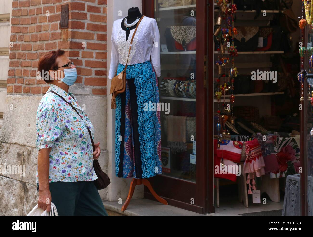 Cracow. Krakow. Poland. Masked woman watching shopwindow. Stock Photo