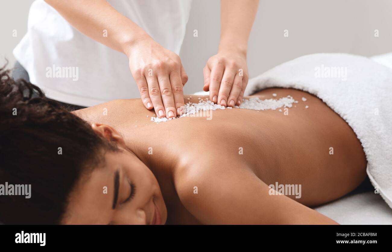 African american lady getting salt massage at modern spa Stock Photo