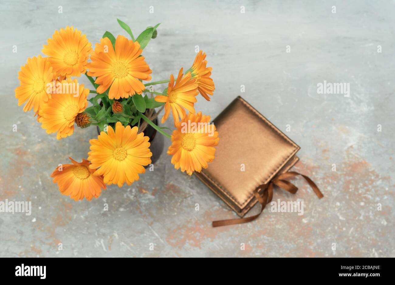 Beautiful vintage present box tied with silk ribbon decorated with marigold flower bouquet. Colorful background for celebration decoration design. Vintage wallpaper. Copy space. Stock Photo