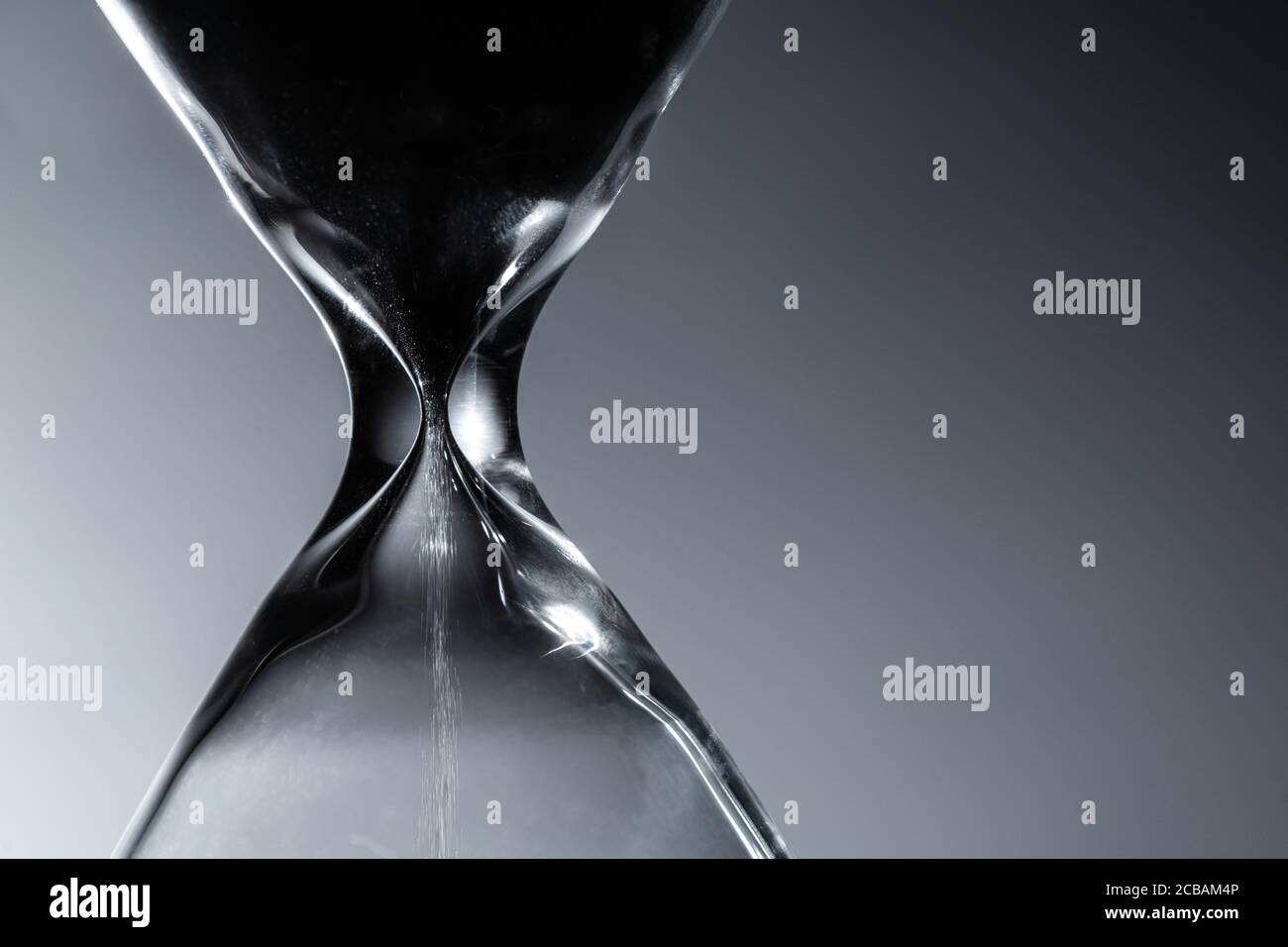 Contemporary Large Hourglass or Sandglass in a Dark Close Up. Old Times Timepiece Technology. Stock Photo