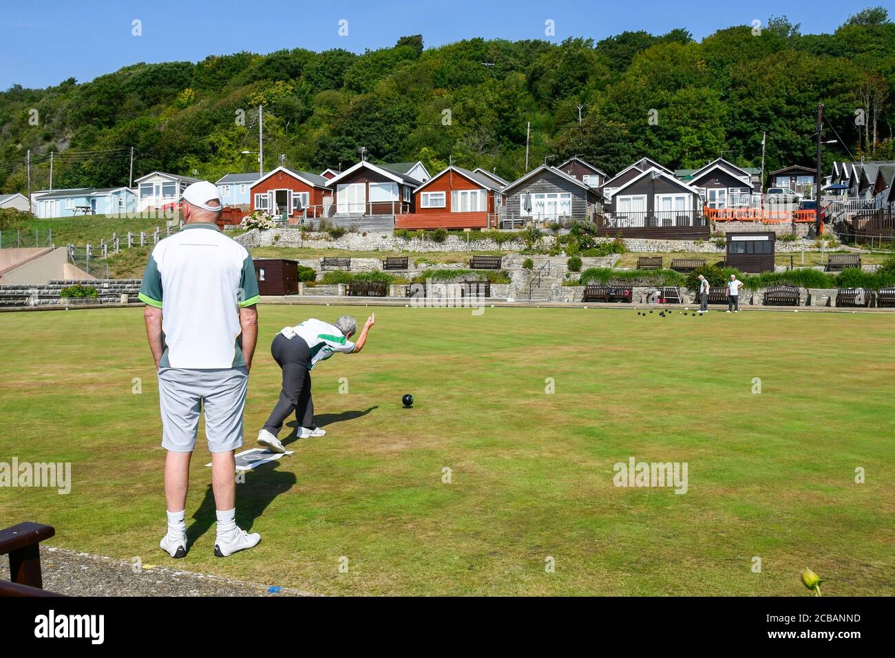 Lyme Regis, Dorset, UK.  12th August 2020.  UK Weather.  Members of the Lyme Regis Bowling Club enjoying a game on the bowls green at the seaside resort of Lyme Regis in Dorset on another scorching hot sunny day as the heatwave continues.  Picture Credit: Graham Hunt/Alamy Live News Stock Photo