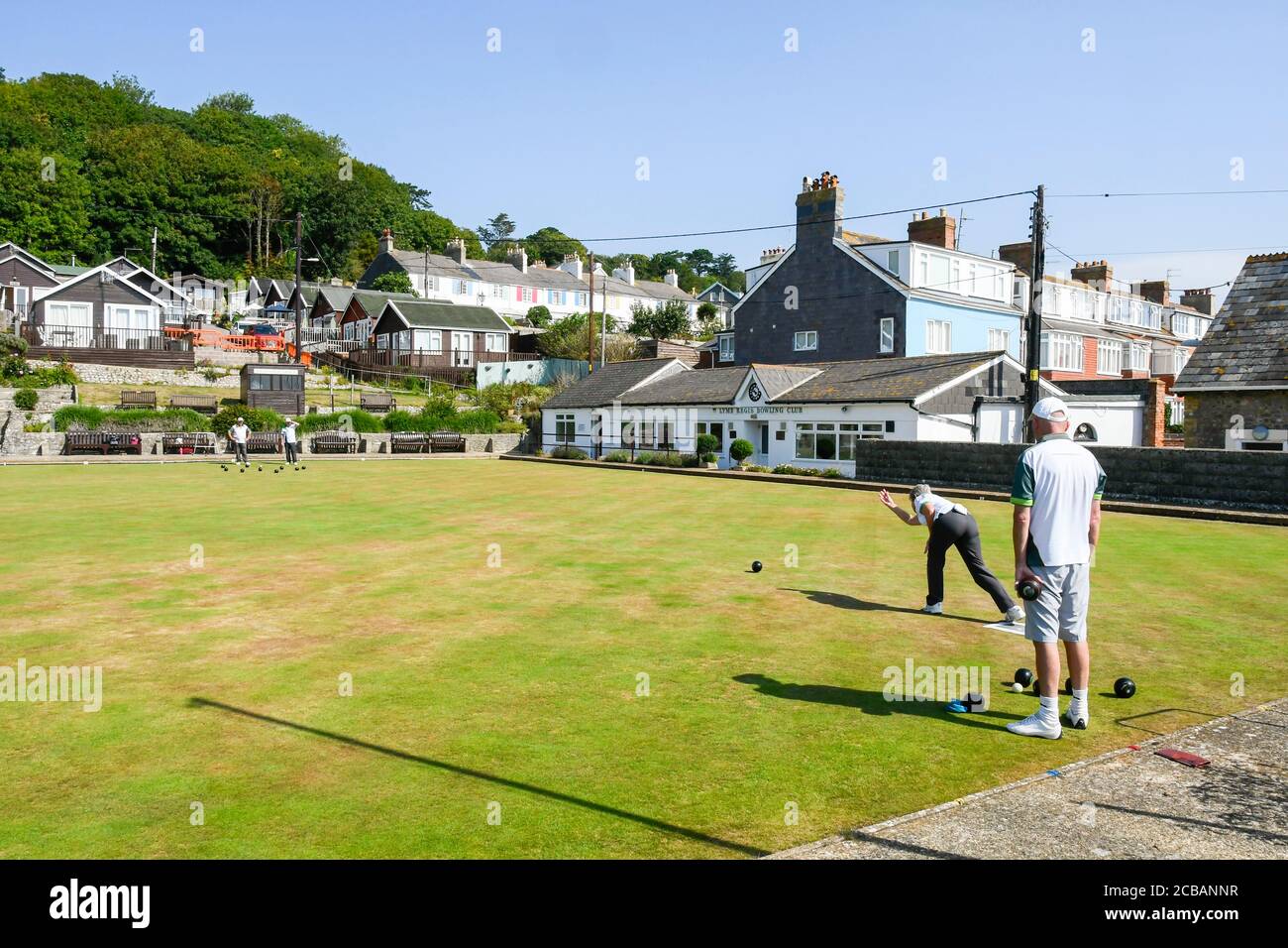 Lyme Regis, Dorset, UK.  12th August 2020.  UK Weather.  Members of the Lyme Regis Bowling Club enjoying a game on the bowls green at the seaside resort of Lyme Regis in Dorset on another scorching hot sunny day as the heatwave continues.  Picture Credit: Graham Hunt/Alamy Live News Stock Photo