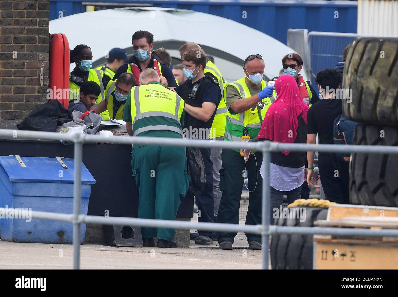 A group of people thought to be migrants have their temperature checked as they are brought into Dover, Kent, by Border Force officers following a number of small boat incidents in the Channel earlier today. Stock Photo
