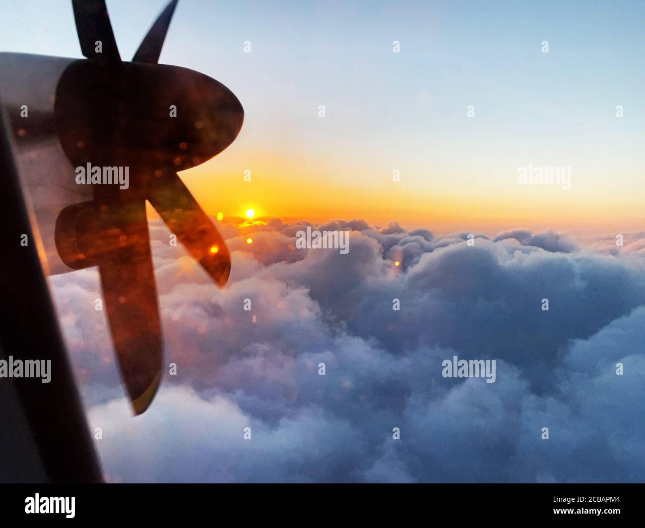 Romantic view from the window of a propeller flight into the rising sun ...