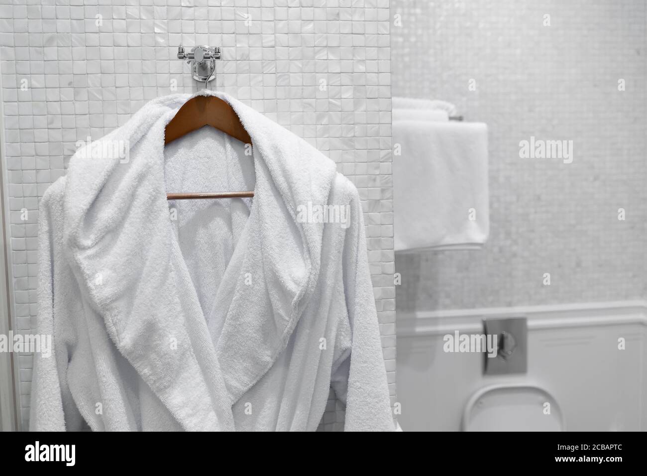 white coat on a hanger in the hotel bathroom Stock Photo