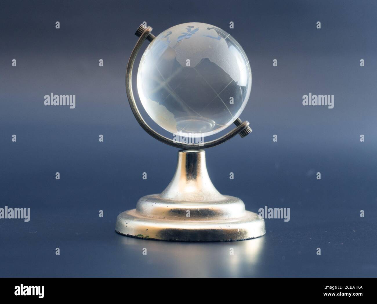 White crystal transparent Globe or globes isolated ball which standing on metal golden frame. Stock Photo