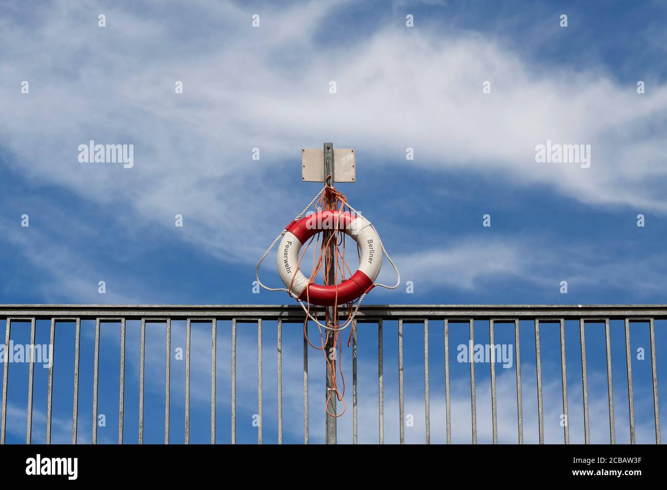 Lifebuoy on the railing of a bridge over a river Stock Photo