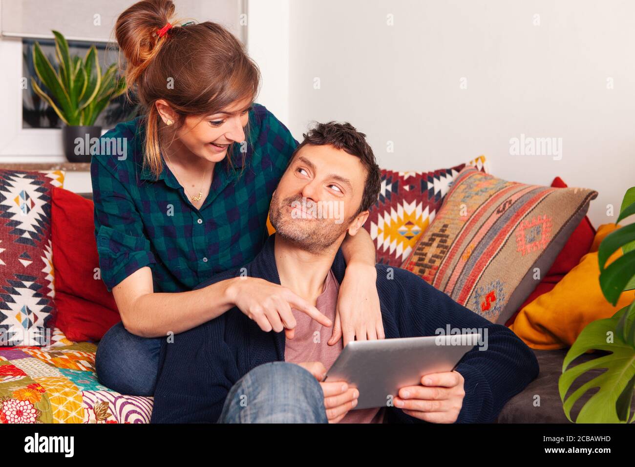 cheerful happy couple at home using tablet Stock Photo