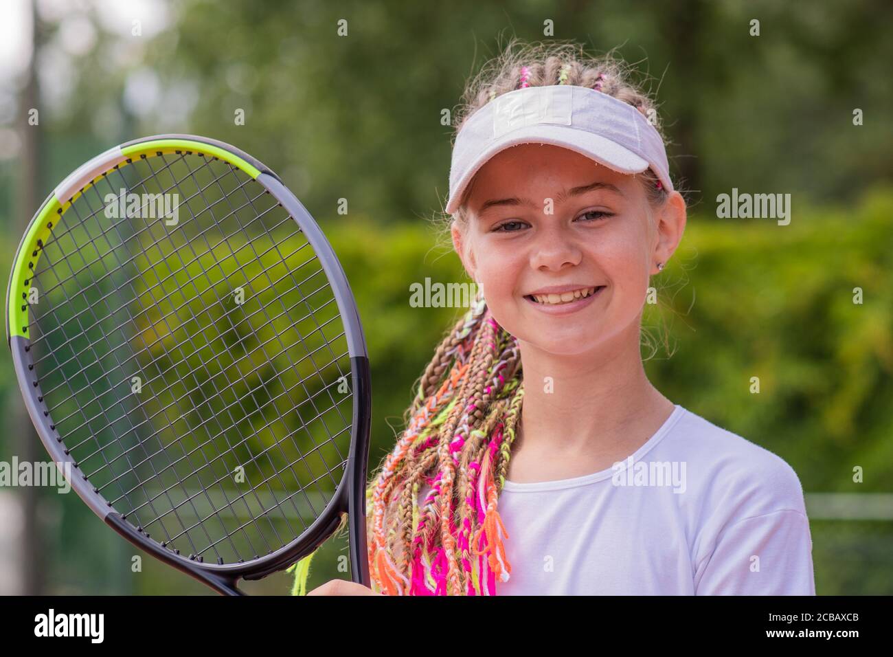 Beginner girl tennis player with a tennis racket in her hands Stock