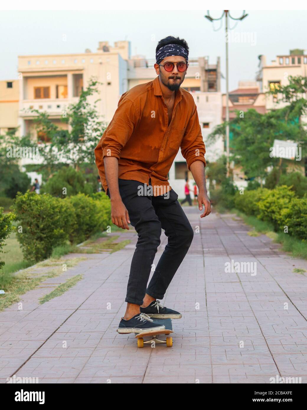 Indian Smart Boy Skate Boarding In Garden Stock Photo
