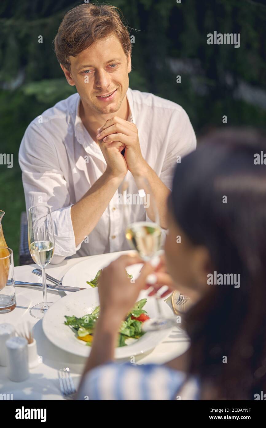 Portrait of blue eyed easygoing man resting with woman in the restaurant Stock Photo