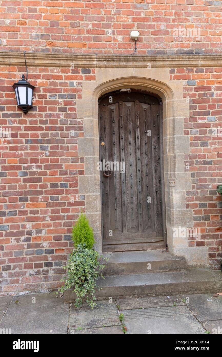 Kent-August-2020-England-A close up view of a small wooden door on the side of a brick building Stock Photo