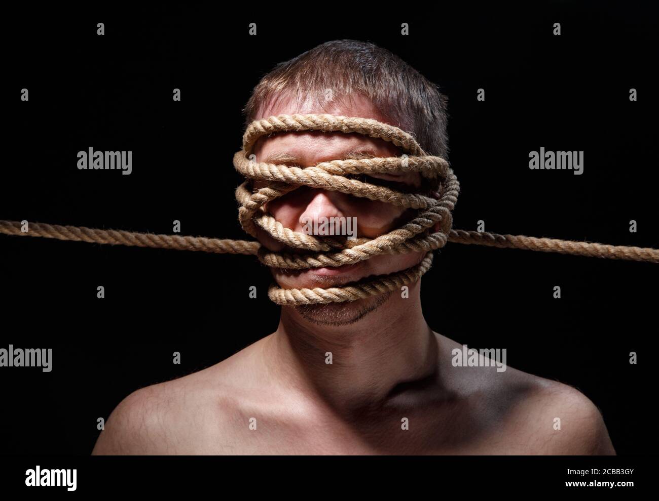 Picture of binded scary man with rope on face Stock Photo