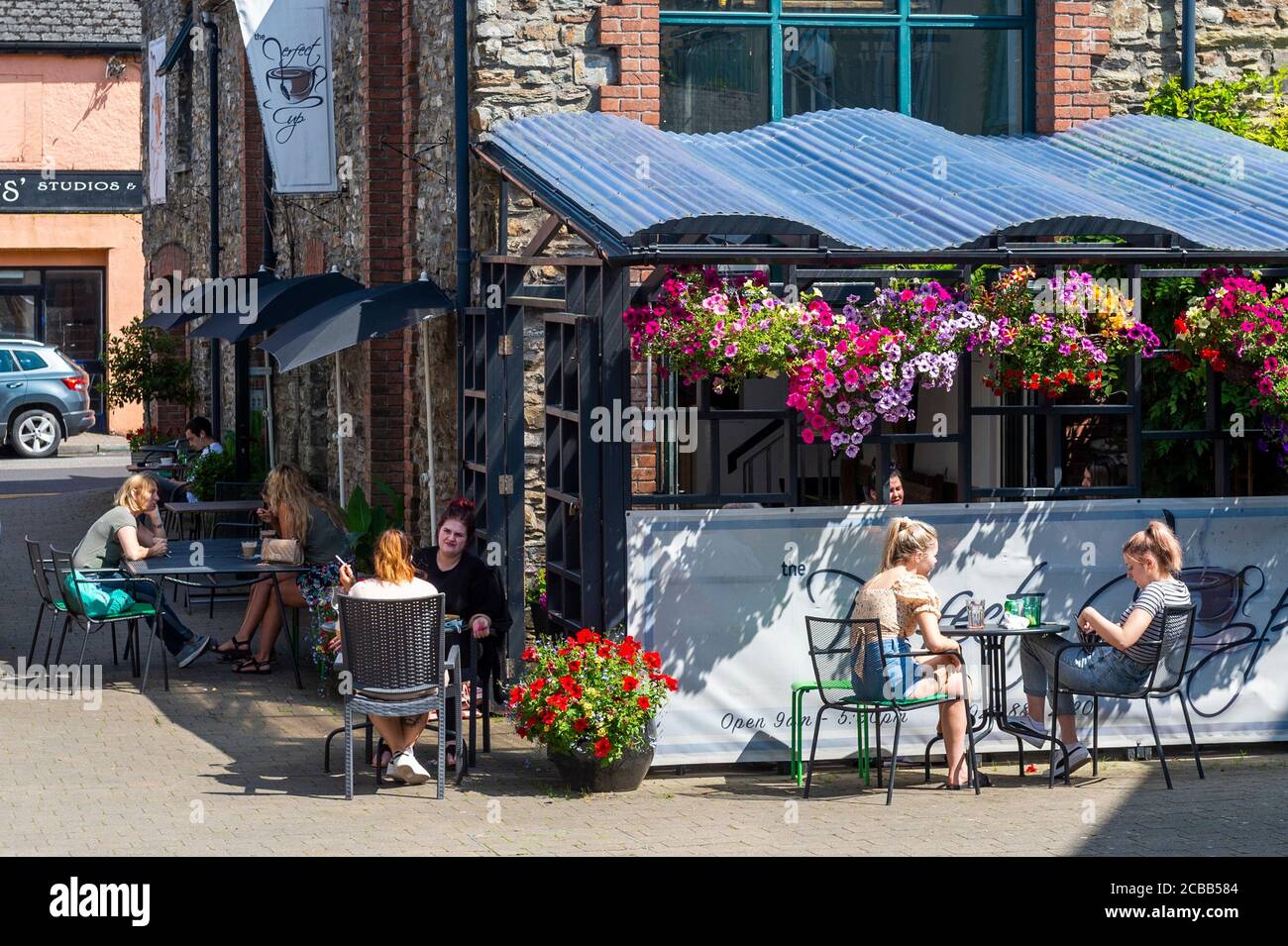 Bandon, West Cork, Ireland. 12th Aug, 2020. Outdoor seating at cafés is becoming the new normal with the COVID-19 pandemic upon us. People eat and drink outside a café in Bandon this afternoon. Credit: AG News/Alamy Live News Stock Photo