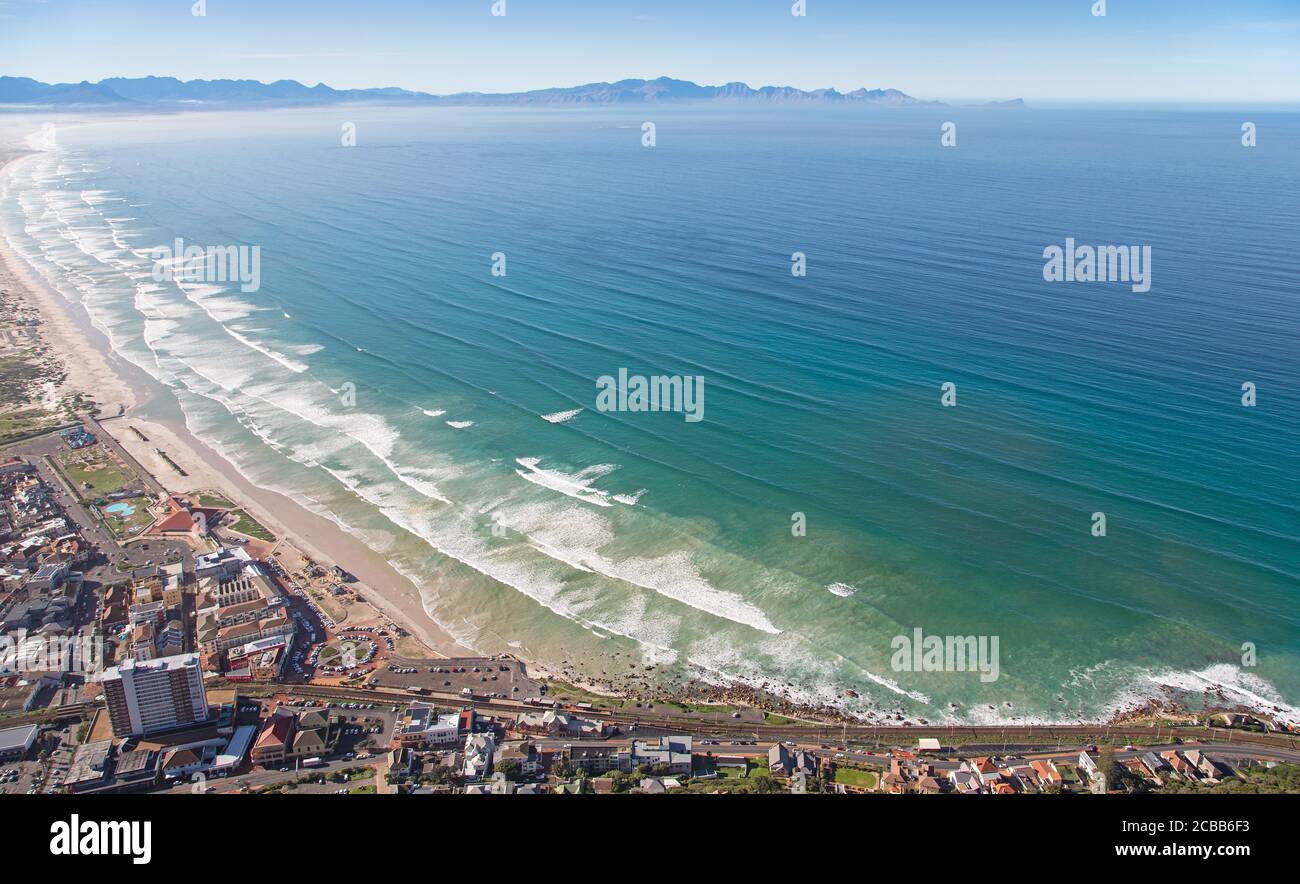 Cape Town, Western Cape / South Africa - 06/30/2020: Aerial photo of surfers and waves at Muizenberg Beach Stock Photo