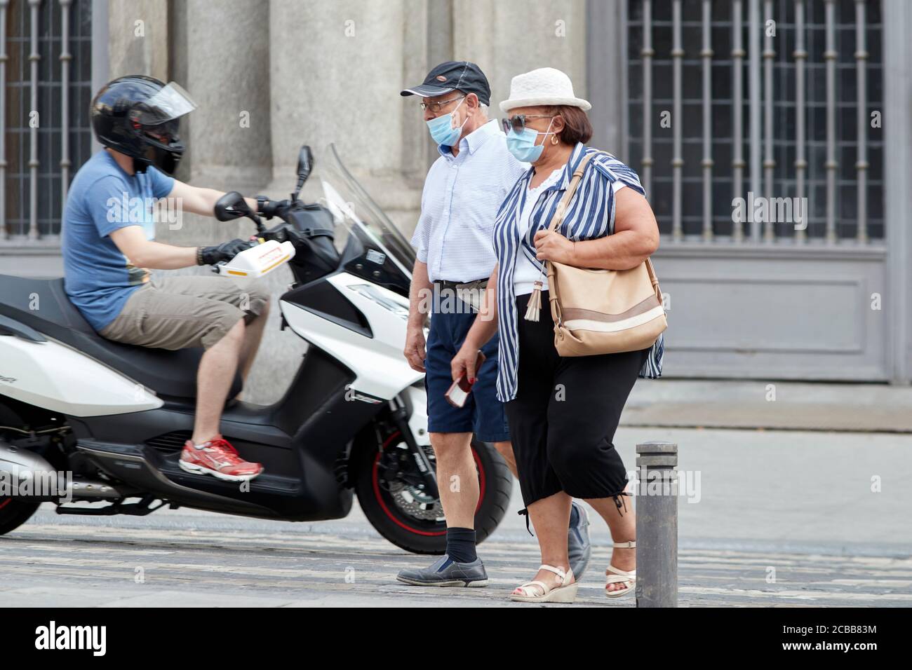 Madrid, Spain - August 8, 2020: Tourists and walkers walk through the city of in a sunset in the city of Madrid. People wear a mask to protect yoursel Stock Photo