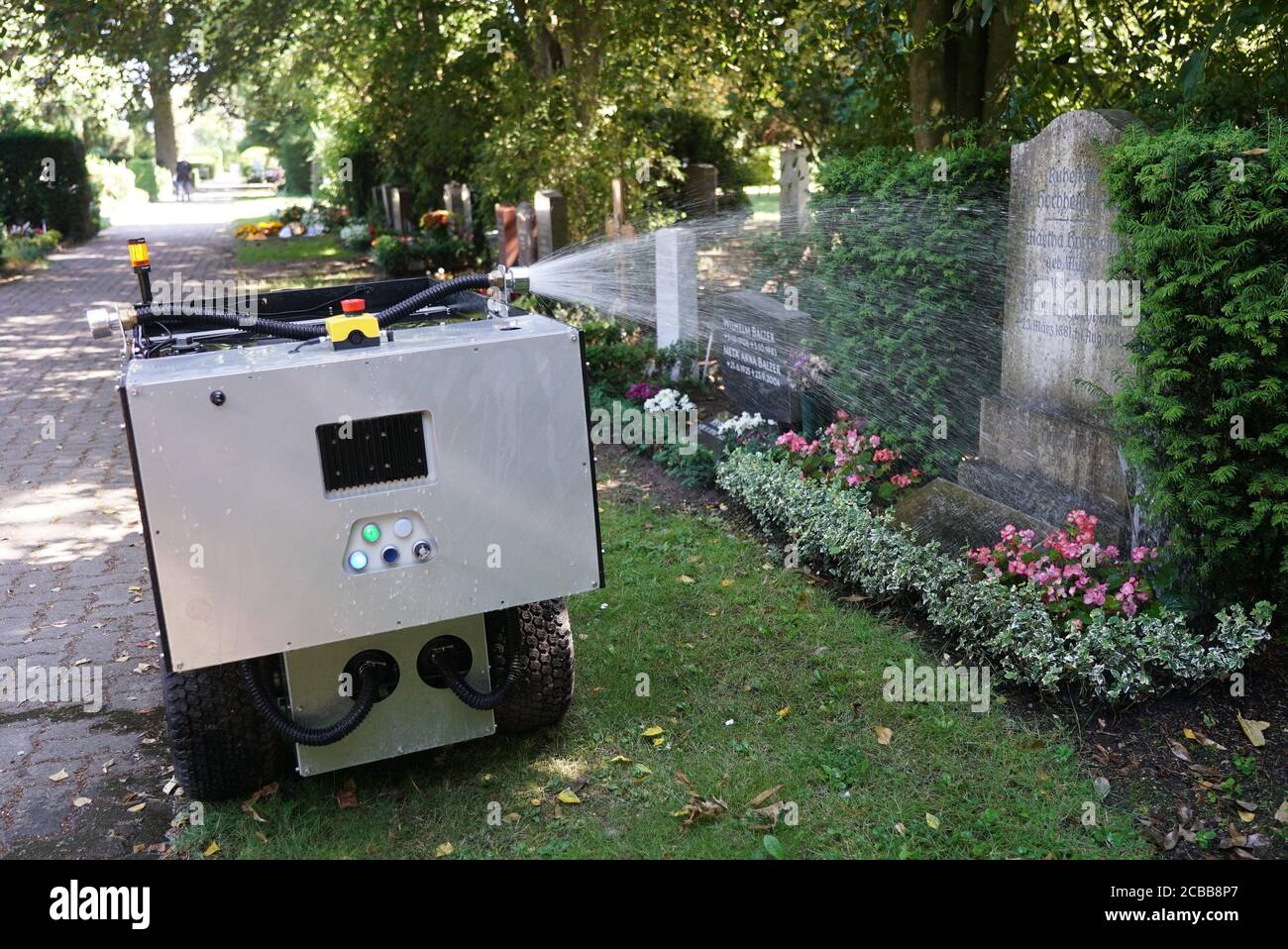 Hamburg, Deutschland. 12th Aug, 2020. Heat - Summer - The flowers, trees and bushes on the grave of the Ohlsdorf cemetery are now automatically supplied with sufficient water. A robot was programmed in such a way that it drives the paths between the graves independently and pours the places that were programmed into it beforehand. | usage worldwide Credit: dpa/Alamy Live News Stock Photo