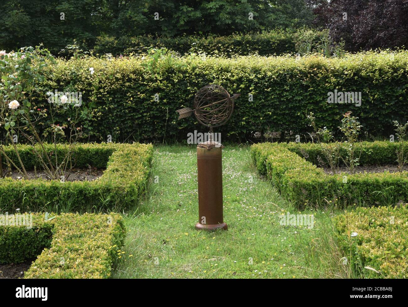 rose garden with armillary and box hedges Stock Photo