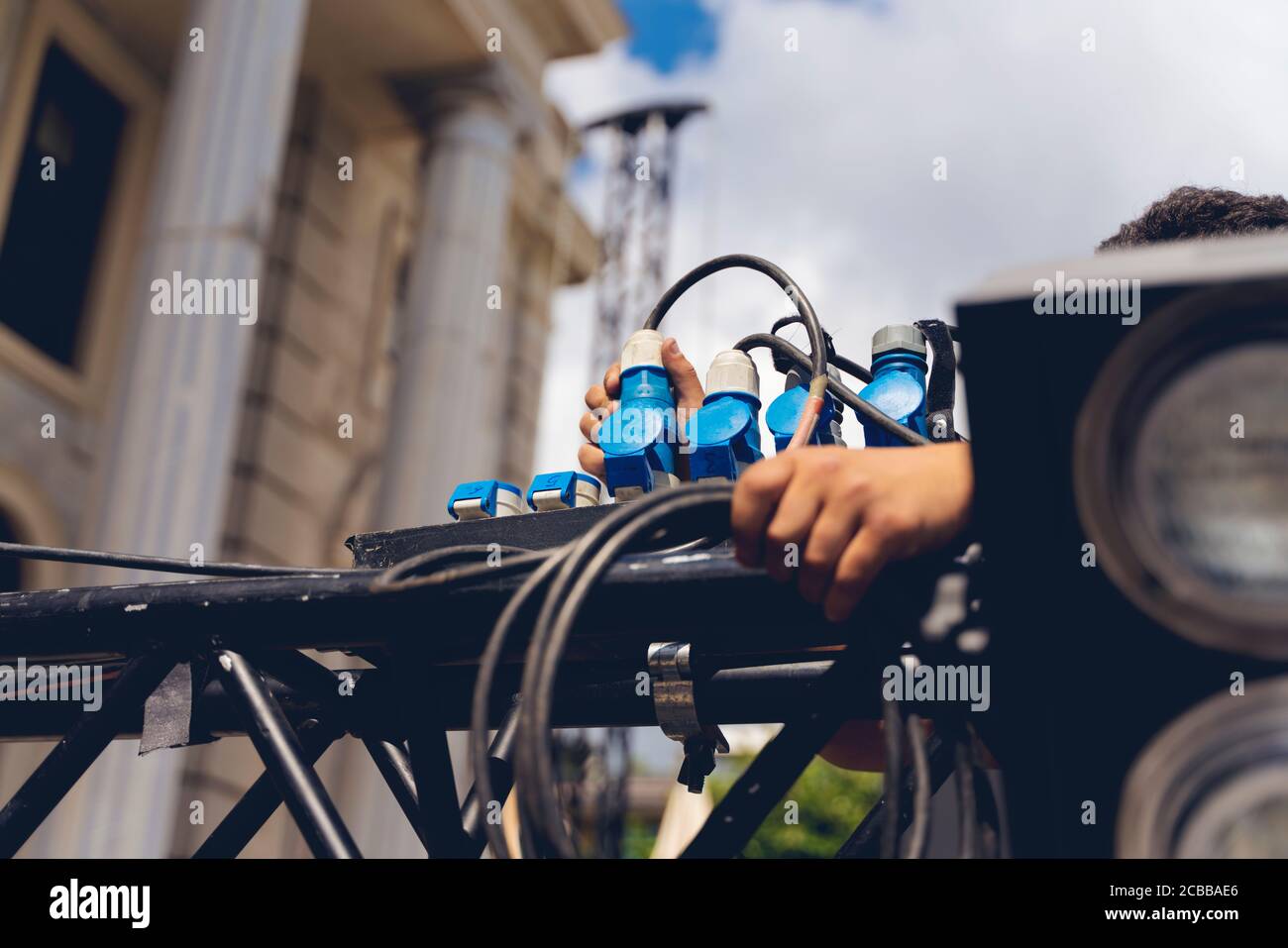 lighting technician iinstalling professional lighting equipment for