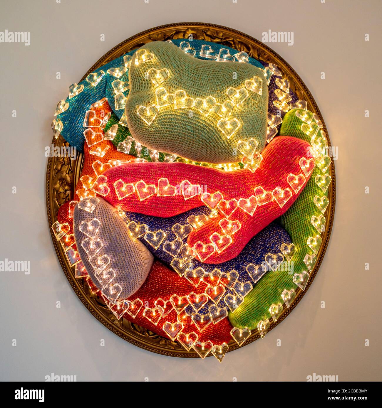 Heart Break 2015 by Joana Vasconcelos. A crocheted art installation in an oval frame, illuminted with heart shaped LED lights. Stock Photo