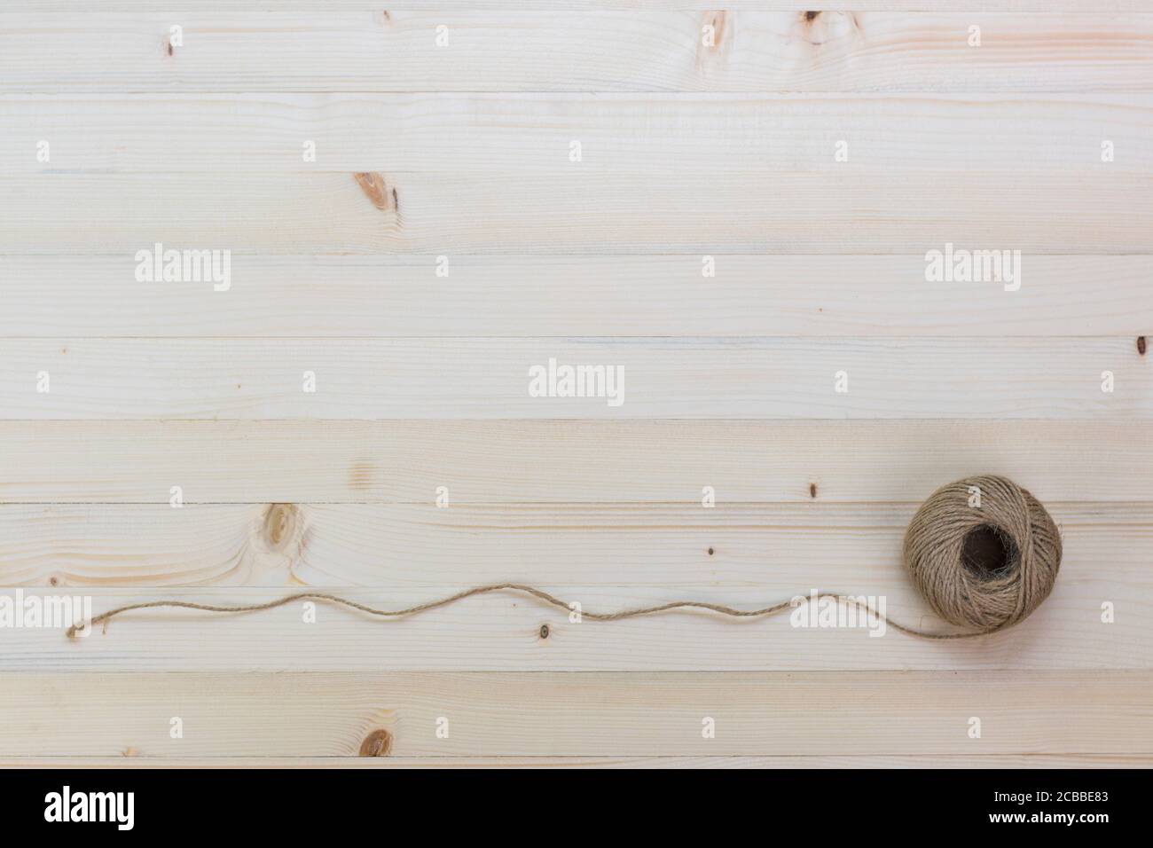Hemp rope roll placed on a pine floor background. Stock Photo
