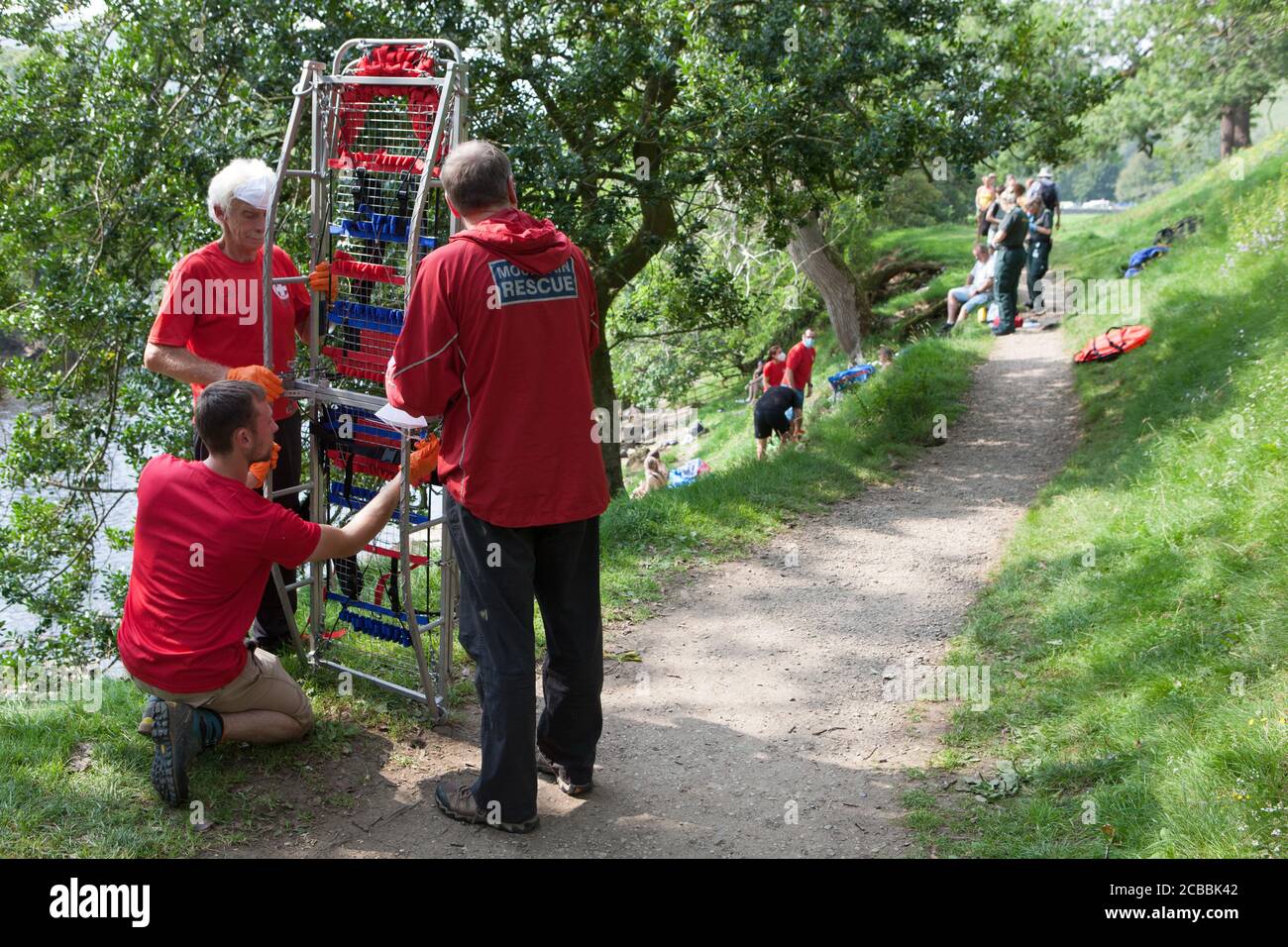 Yorkshire, UK, 12 August 2020: An ambulance crew and a Mountain Rescue team was called out to incident near Appletreewick, where a woman had a suspected broken ankle and had to be stretchered out. Dozens of holiday makers and locals took advantage of the 28 degree heat to swim in the river Wharfe in the Yorkshire Dales National Park. Anna Watson/Alamy Live News Stock Photo