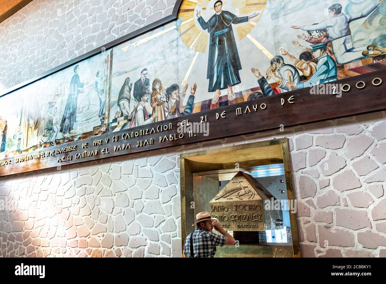 A pilgrim views the remains of Saint Toribio Romo in the Sanctuary of Santa Ana de Guadalupe, Jalisco State, Mexico. Father Toribio was a Mexican Catholic priest and martyr who was killed during the anti-clerical persecutions of the Cristero War. Stock Photo