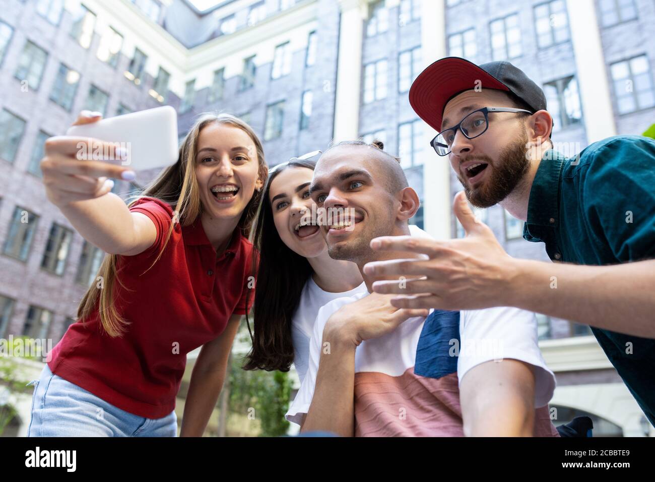 Taking selfie. Group of friends taking a stroll on city's street in ...