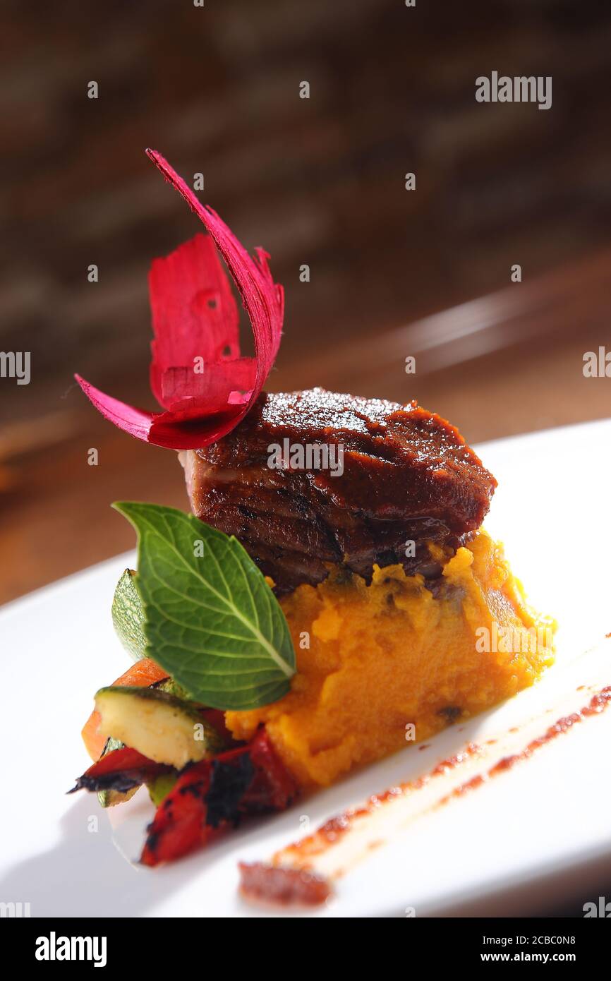 Vertical shot of carrot puree with eggplant and beetroot on the top Stock Photo