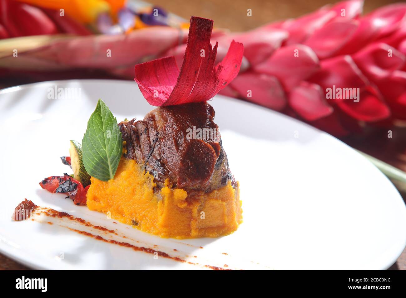 Selective focus shot of carrot puree with eggplant and beetroot on the top Stock Photo
