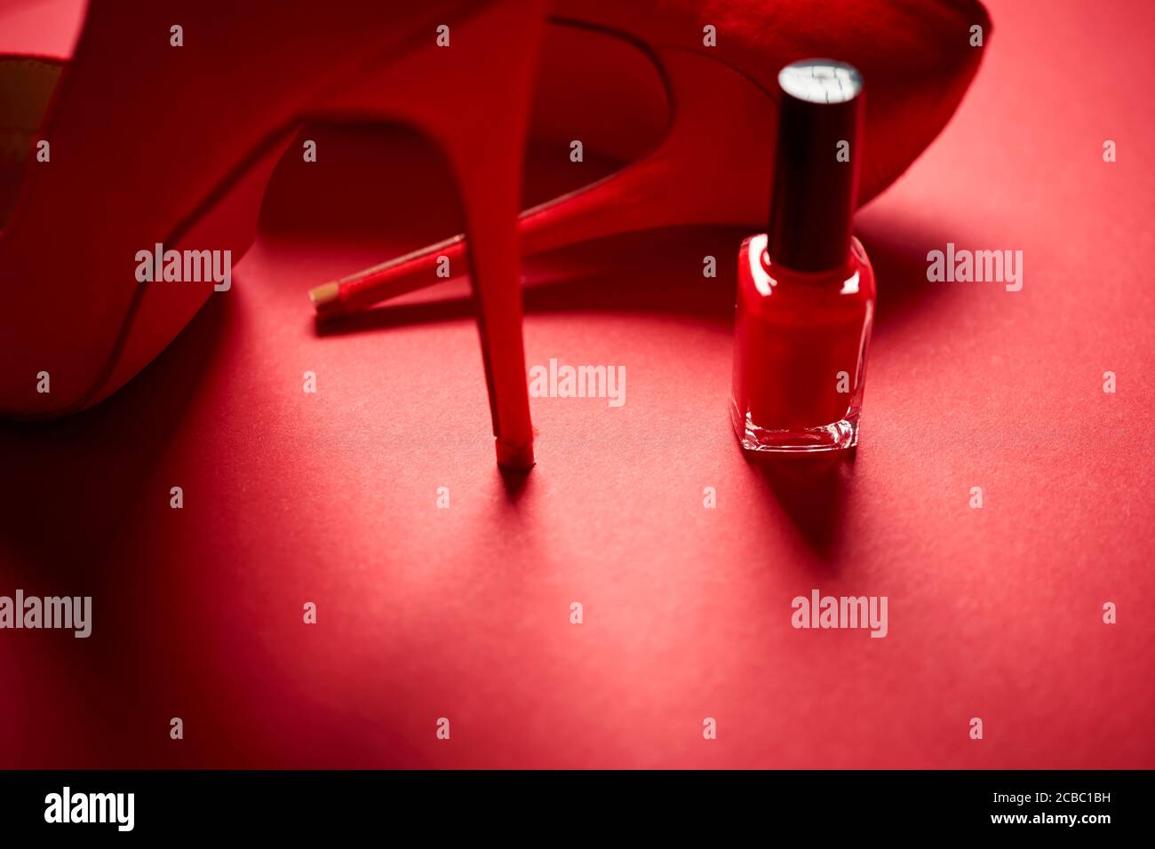 red high heel shoes and nail polish on a minimalist background Stock Photo