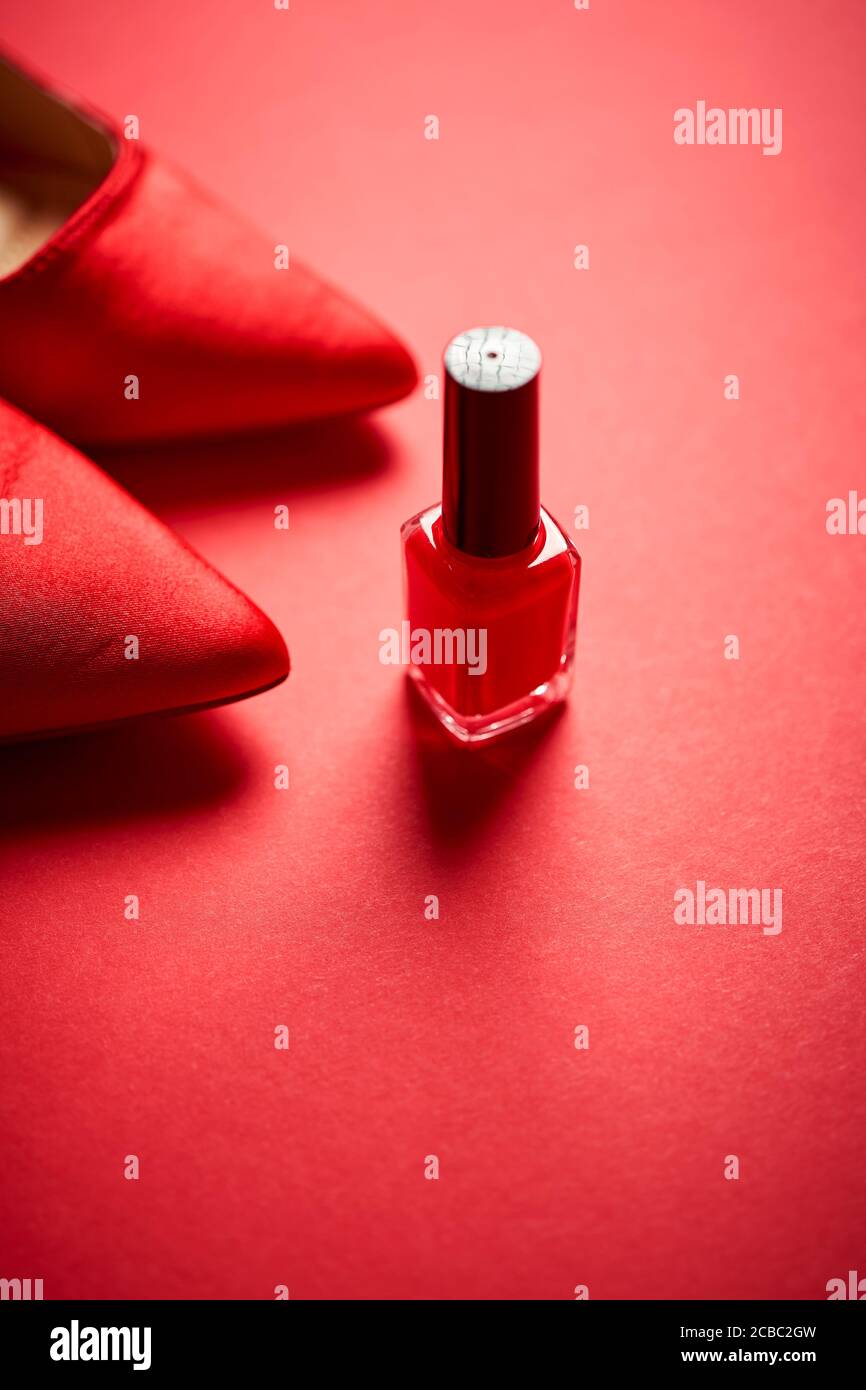 red high heel shoes and nail polish on a minimalist background Stock Photo