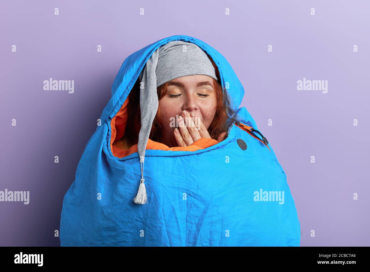 funny young tourist with closed eyes, palm on her mouth,going to fall
