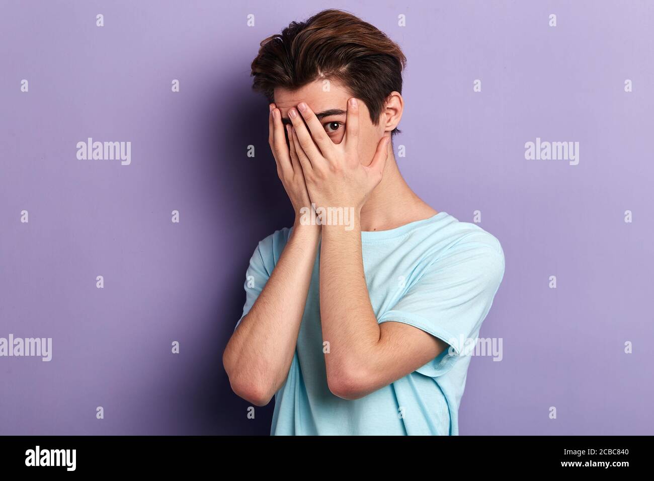 Young man covering face palms hi-res stock photography and images - Alamy