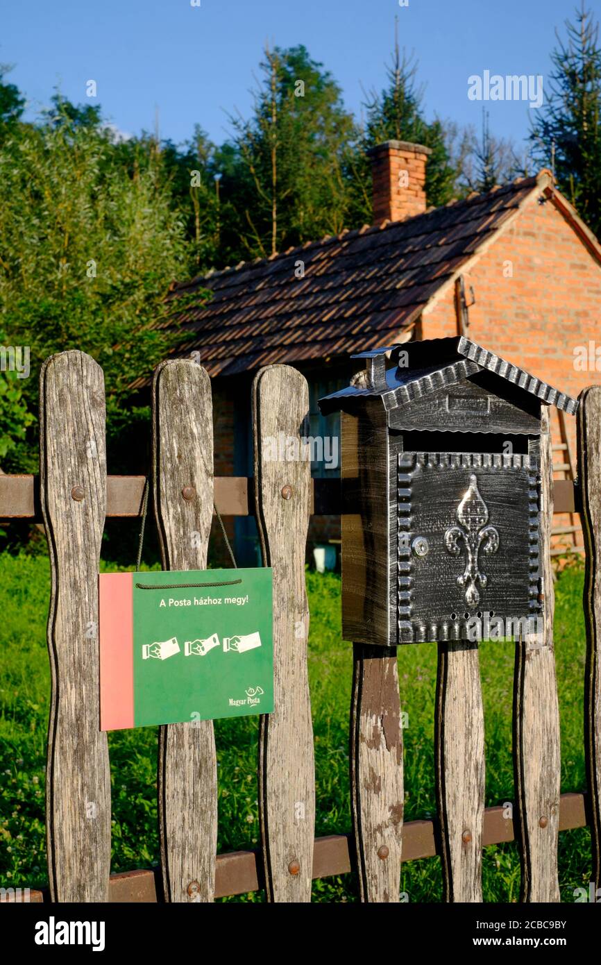 postal sign hanging next to mail box requesting mail delivery person calls at house while doing rounds zala county hungary Stock Photo