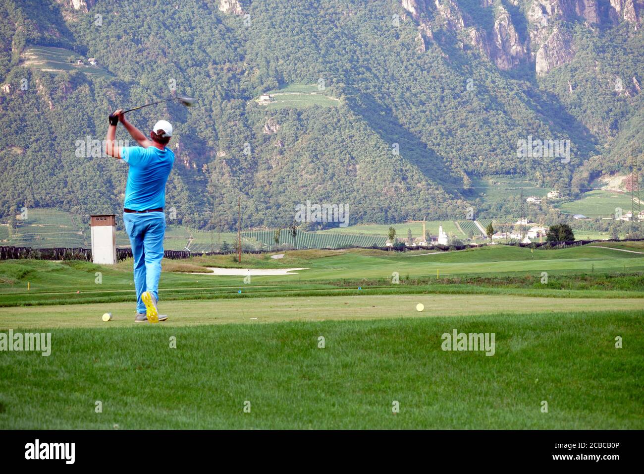 Blurred movement of a male golfer teeing-off at the Blue Monster golf club in South Tirol, Italy in summer of 2020. Stock Photo