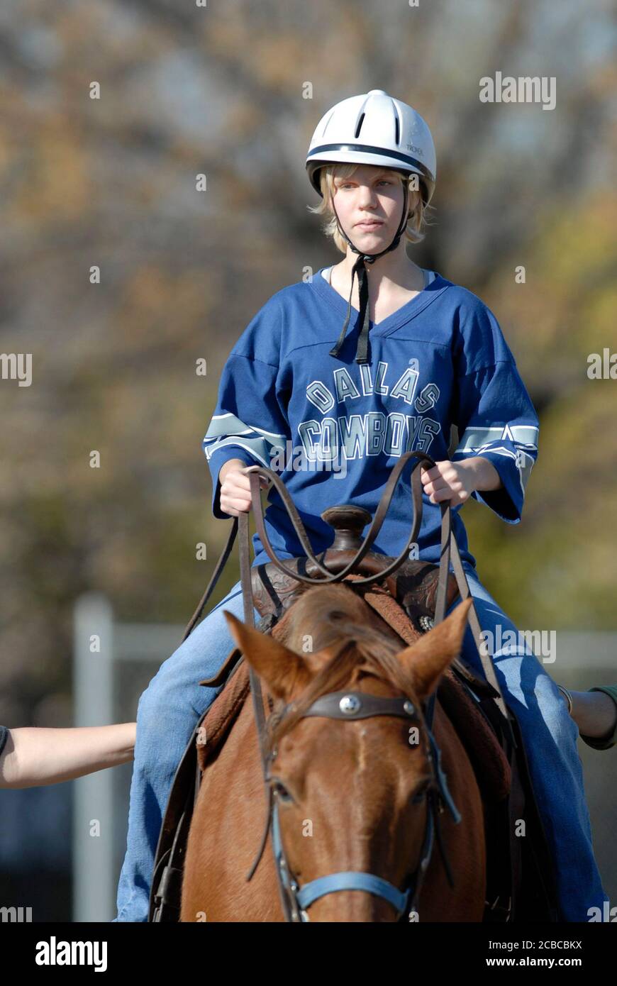 Austin, Texas USA, December 13, 2006: A ninth-grade student who attends Texas School for the Blind and Visually Impaired (TSVBI) experiences horse-riding for the first time during an outing at the school in central Austin.  Area ranchers bring horses to campus once a year to offer new experiences and help build self-confidence for legally blind students.  ©Bob Daemmrich Stock Photo