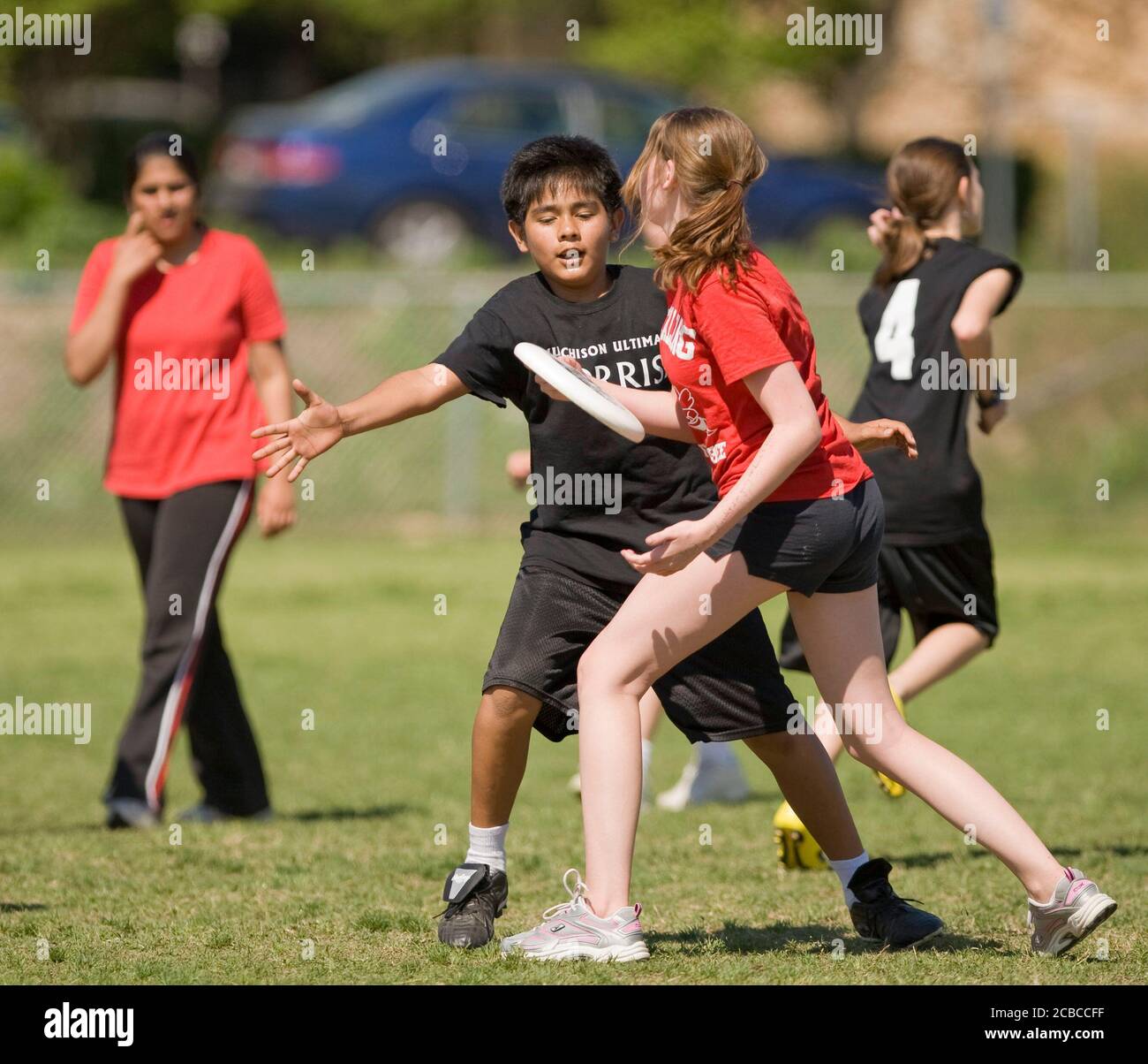 Austin, Texas USA, April 7, 2008: Middle school students from Murchison (black shirts) and Kealing (red shirts) play a competitive game of Ultimate on a spring Saturday afternoon. Each co-ed team starts seven players and uses a flying disc weighing 175 grams in competition.   ©Bob Daemmrich Stock Photo