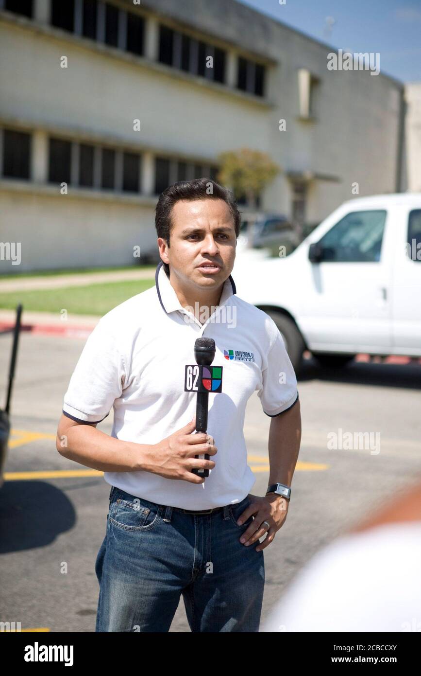 Austin, Texas USA, August 31, 2008: Hispanic television reporter who works for Univision does a live shot, looking at the camera and talking into a microphone, during a visit by President Bush.  ©Bob Daemmrich Stock Photo