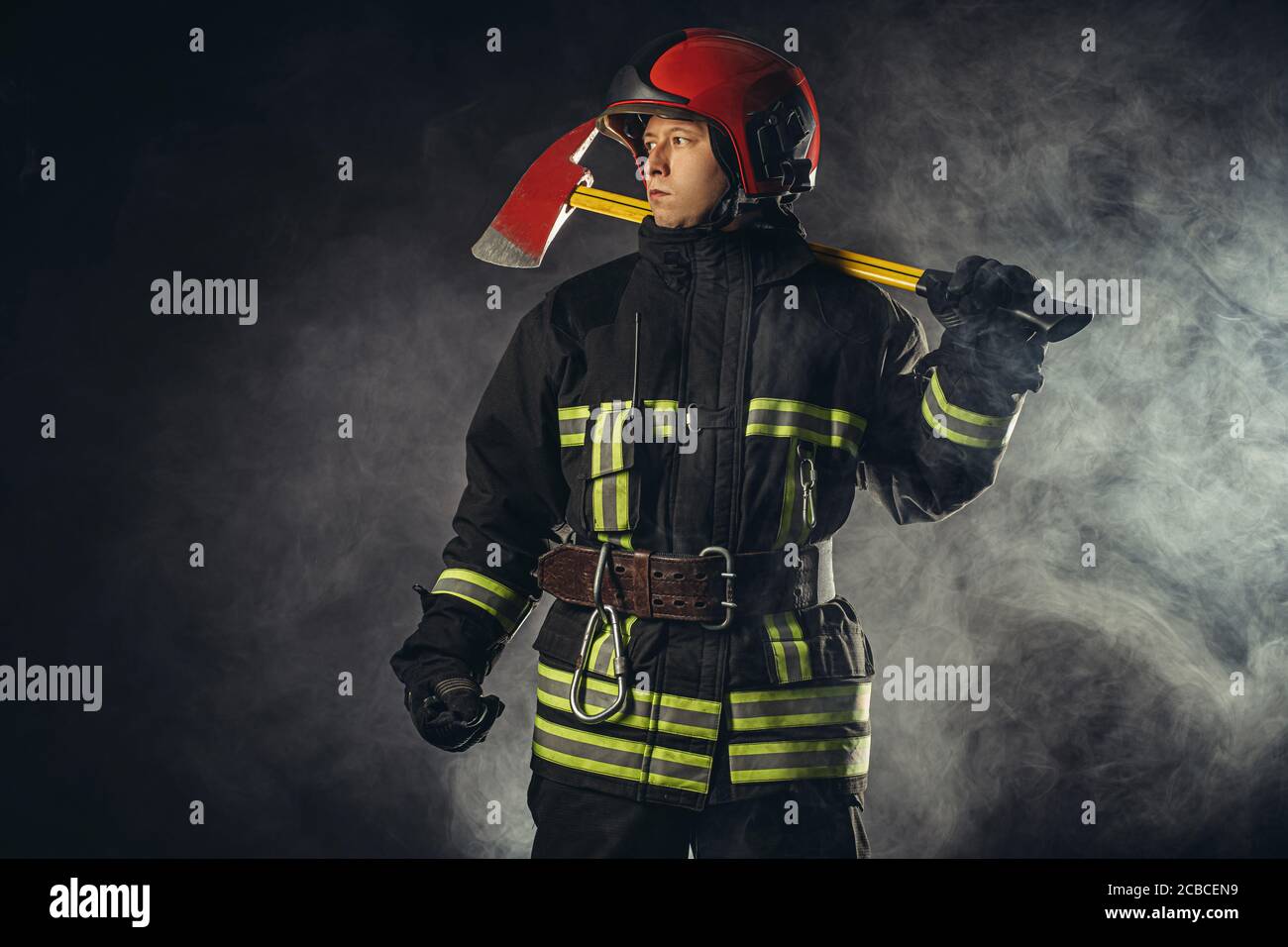 reverent, confident man working in fire station ready to save people from fire in emergency situations, wearing uniform and helmet Stock Photo