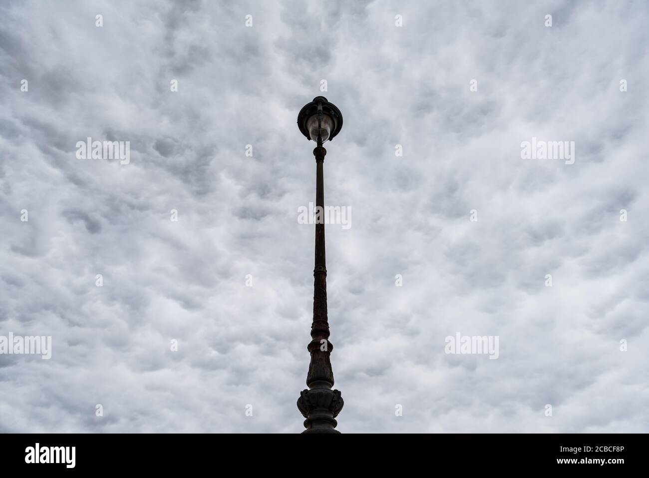 Ornate Street Lanp in Paris Looking Upward to Stratocumulus Cloud Covered Sky Stock Photo