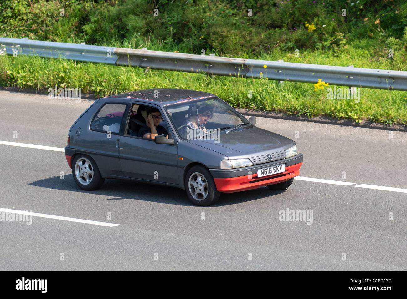 1995 90s grey Peugeot 106 XND; Vehicular traffic moving vehicles, moving cars driving vehicle on UK roads, motors, motoring on the M6 motorway highway network. Stock Photo