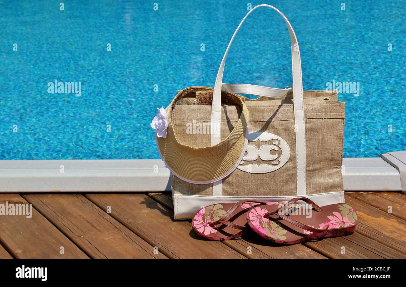 Beach bag and accessories by the edge of a pool Stock Photo Alamy