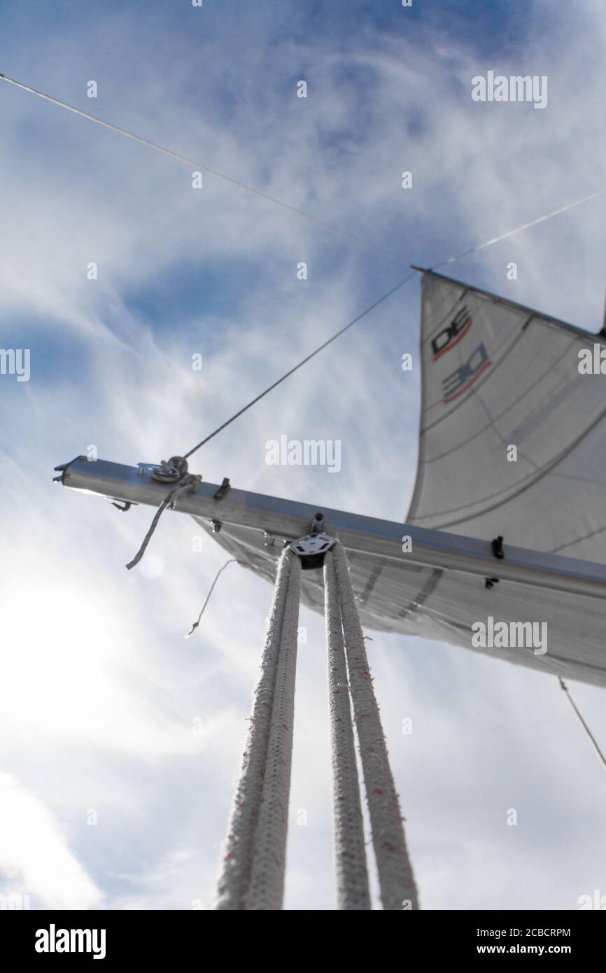 Kharkiv, Ukraine - July 28, 2020: Bottom view of mast and sail of yacht on blue sky background, selective focus Stock Photo