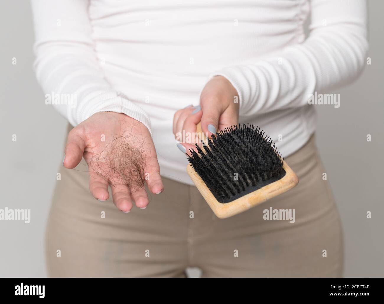 Hair loss problem, postpartum period, menstrual disorder, stress. Many hair fall after combing in hairbrush Stock Photo