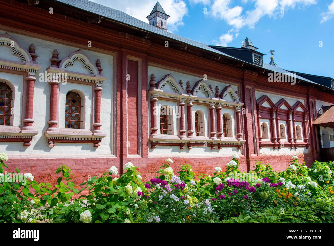 Elegant bright flower bed against the background of the brick wall