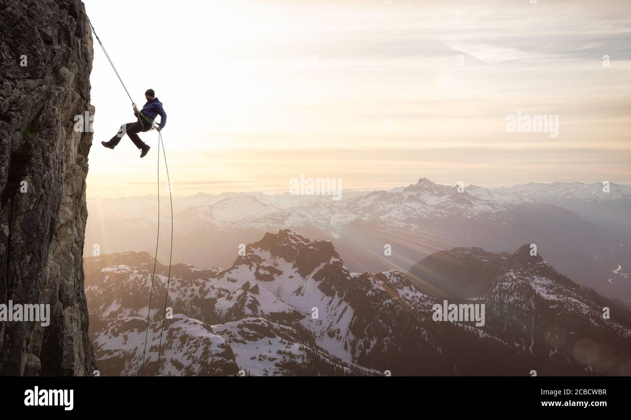 Epic Adventurous Extreme Sport Composite of Rock Climbing Man Rappelling Stock Photo