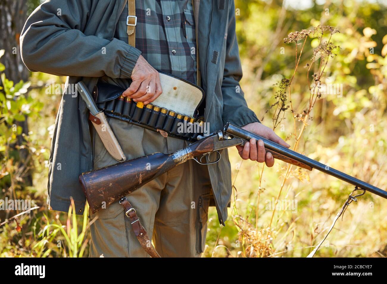 Fowler holding shotgun, cartridges on lower back, ready to shoot on ...